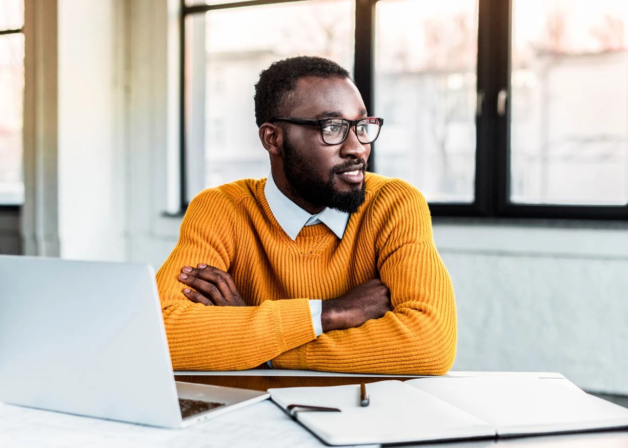 A young well-educated man with a laptop and planner is reviewing deposit rates for his Statement Savings account