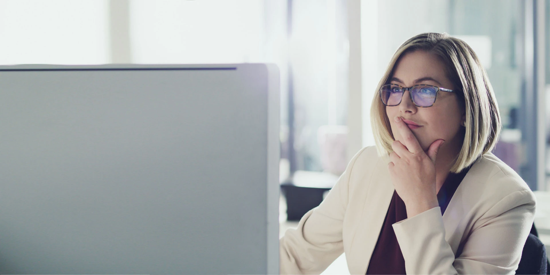 A businesswoman looking at a computer and reading about the fraud mitigation services available to protect her business