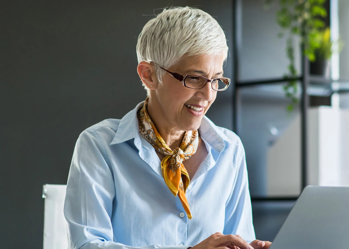 A business owner who is confident and casually dressed is signing up for fraud mitigation services to protect her business
