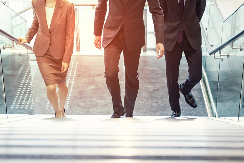 First Midwest’s Leadership Team are walking up the stairs of a modern building