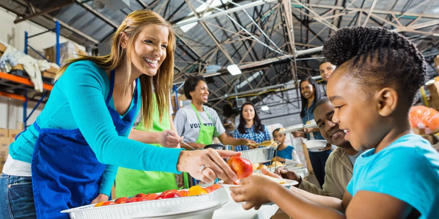 A group of volunteers whose non-profit agency utilizes government and non-profit banking services are distributing food