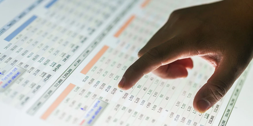 Close up of a hand pointing to a computer screen showing hypothetical business online banking account activity 