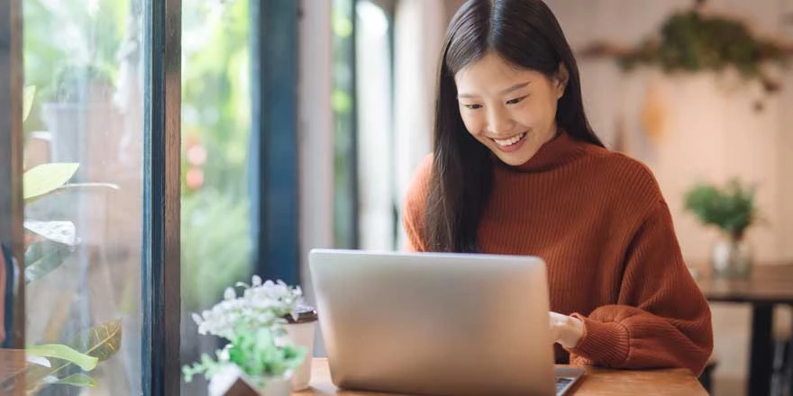 Smiling woman at her laptop typing
