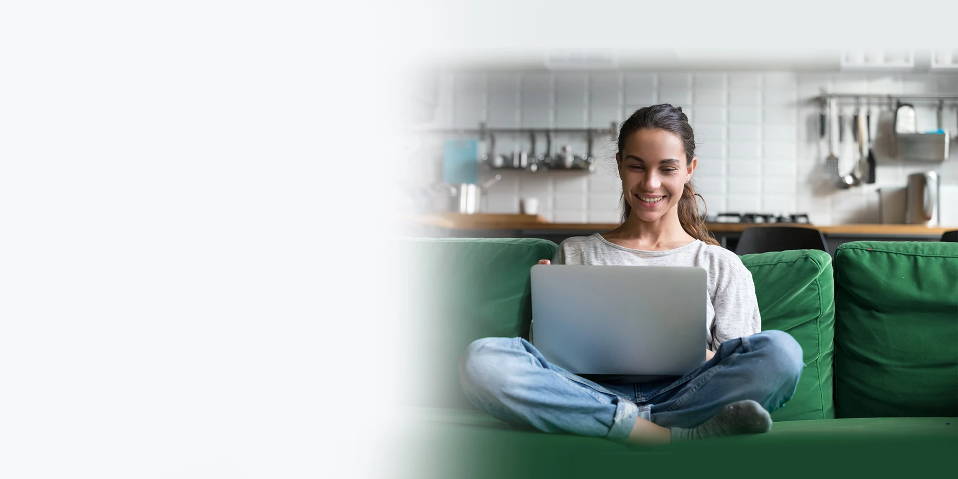 A young lady is using her laptop in a new apartment to review personal account deposit rates