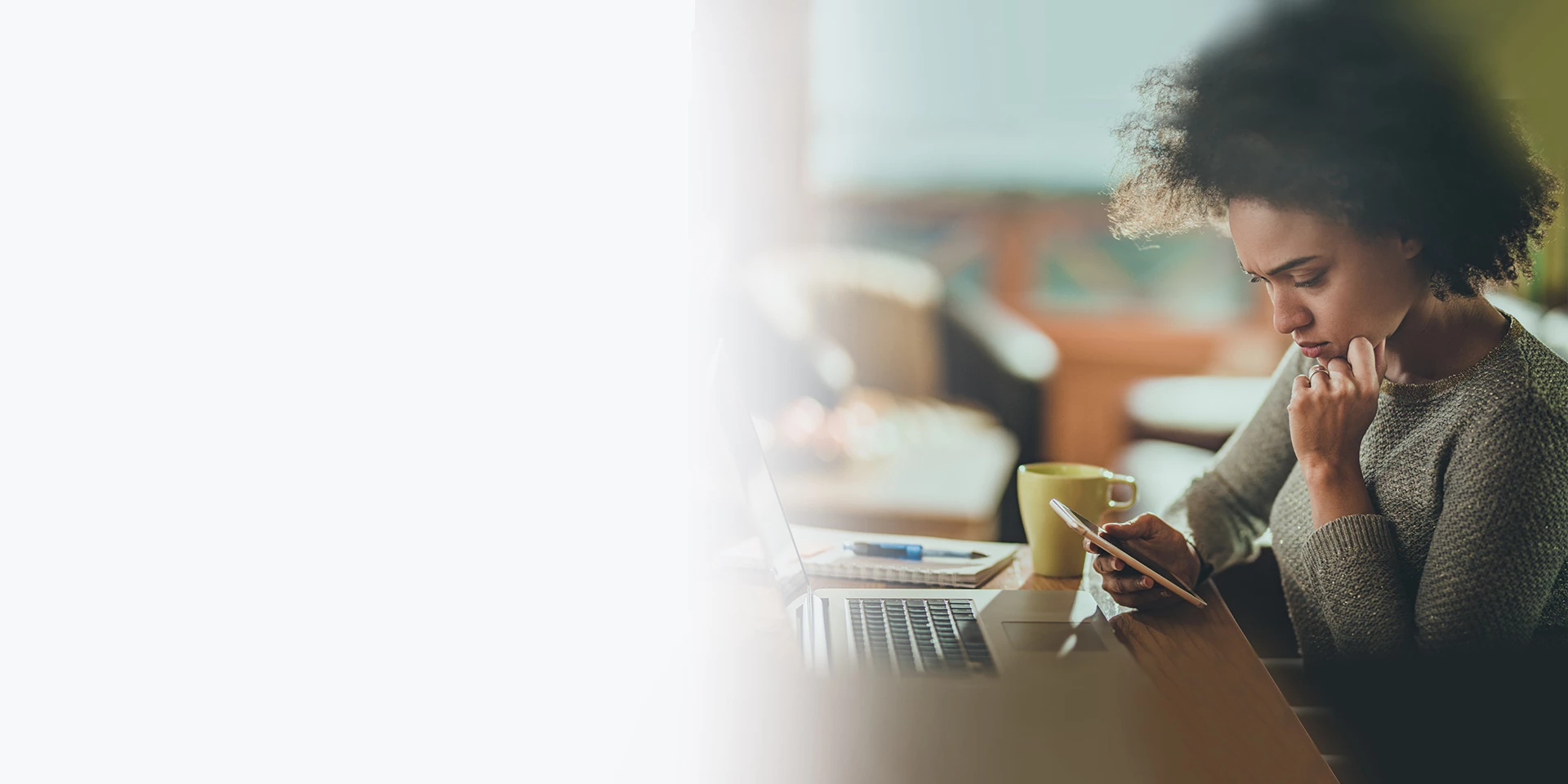 A young woman sitting in a coffee shop ordering checks from her phone