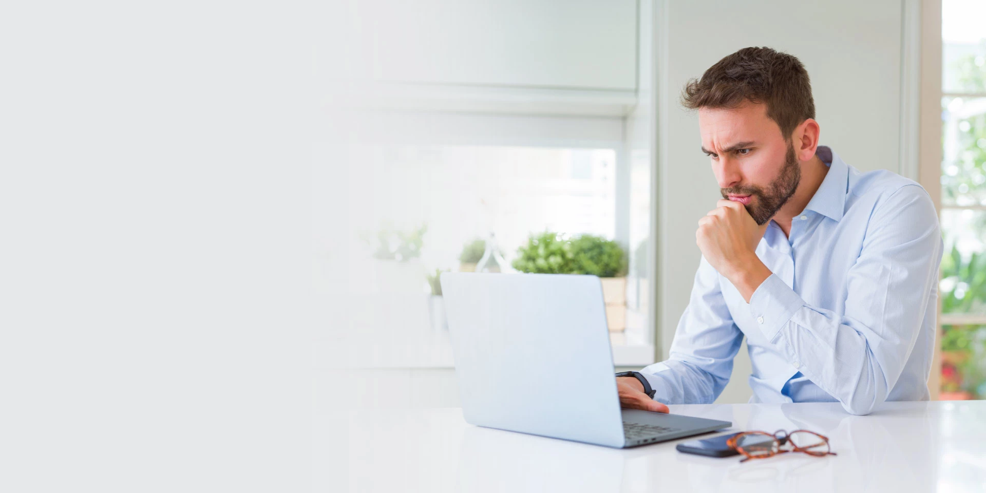 A man researching topics about fraud on his laptop