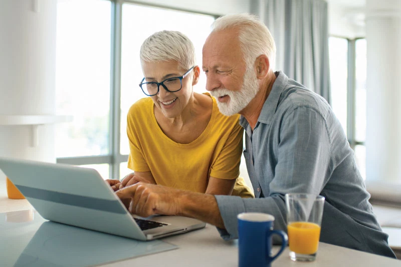 A husband and wife looking at her laptop