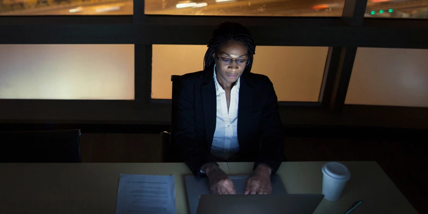 A businesswoman on her laptop researches the best loan syndications for her company