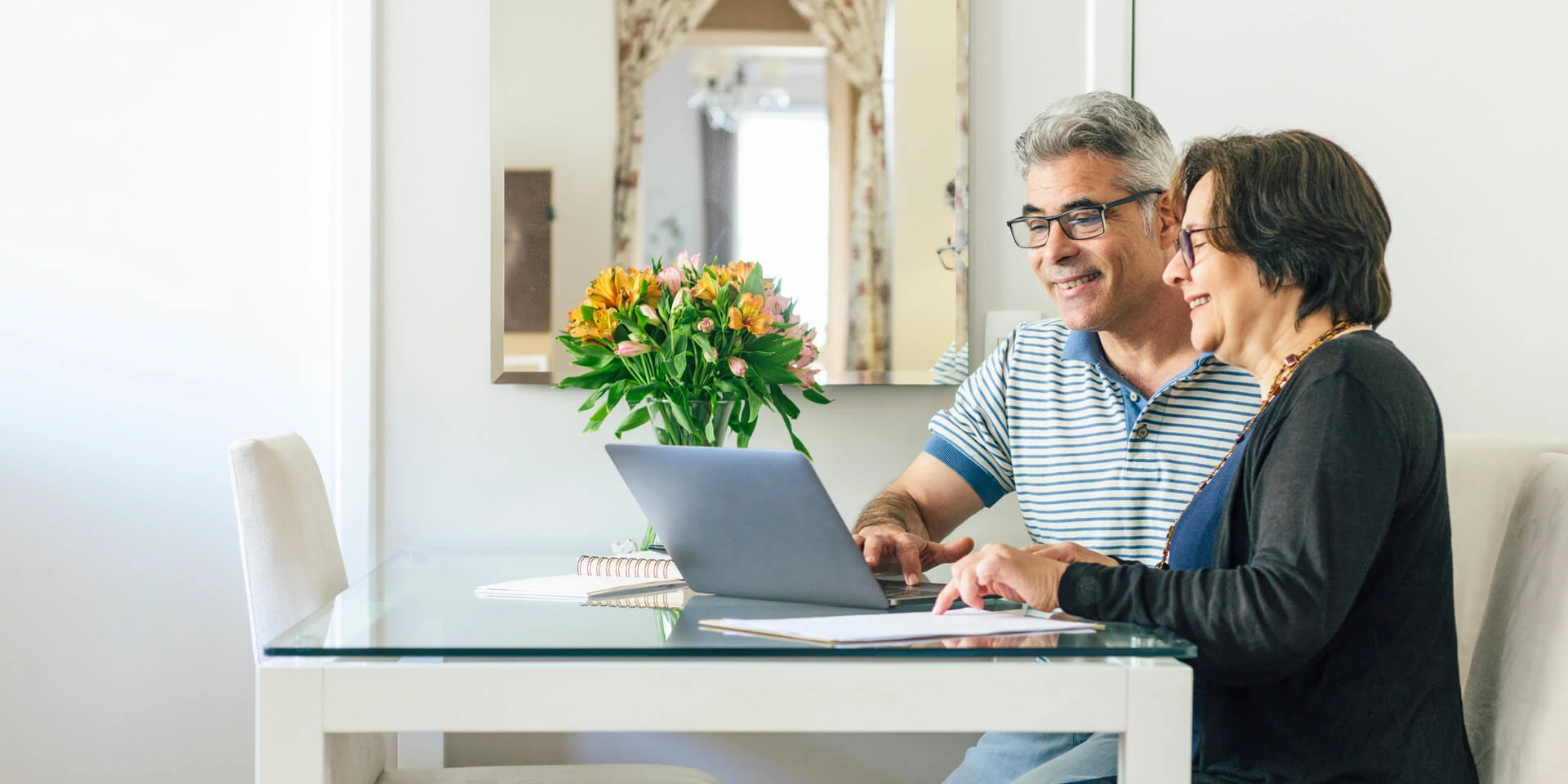 Older Couple looking at a laptop screen.