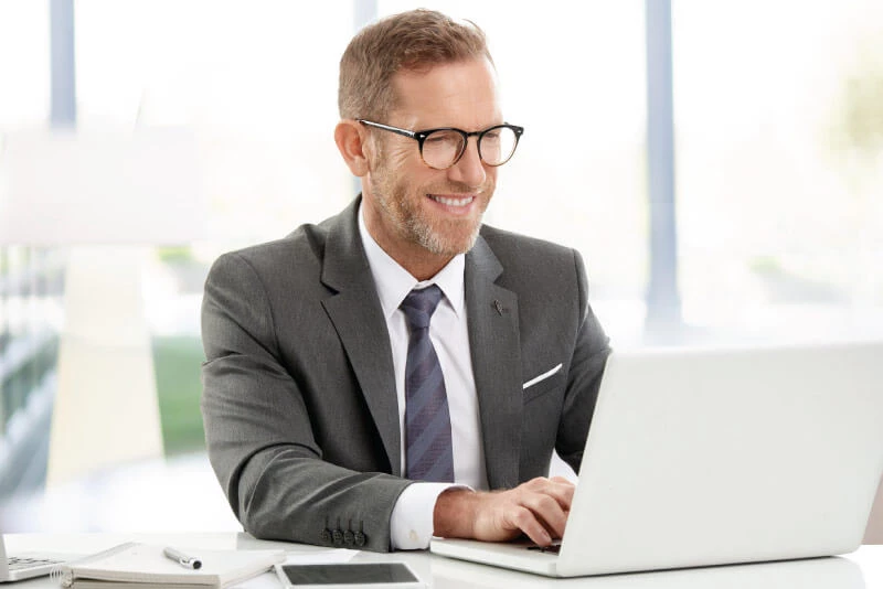 A professional man searching on his laptop for IRAs